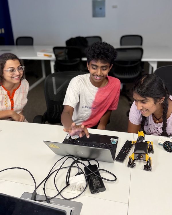 Students programming a robot dog and a LEGO robot car